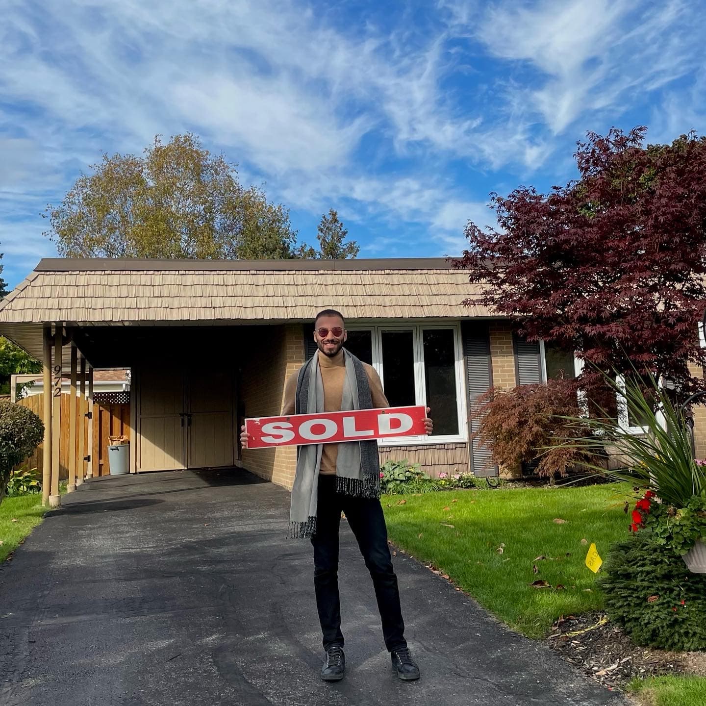 Sold closing in front of a brick house