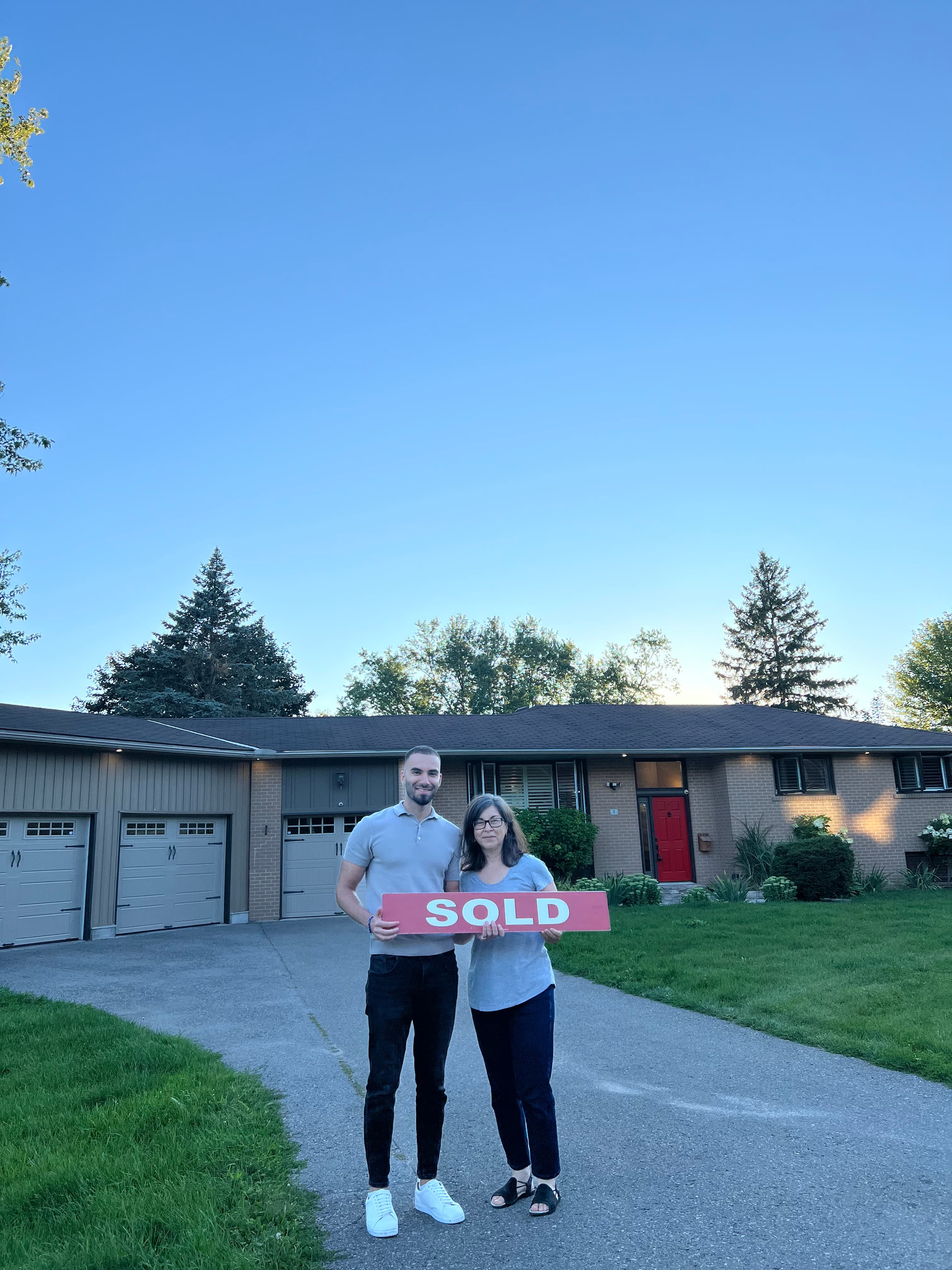 Sold closing with a client outside a brick bungalow
