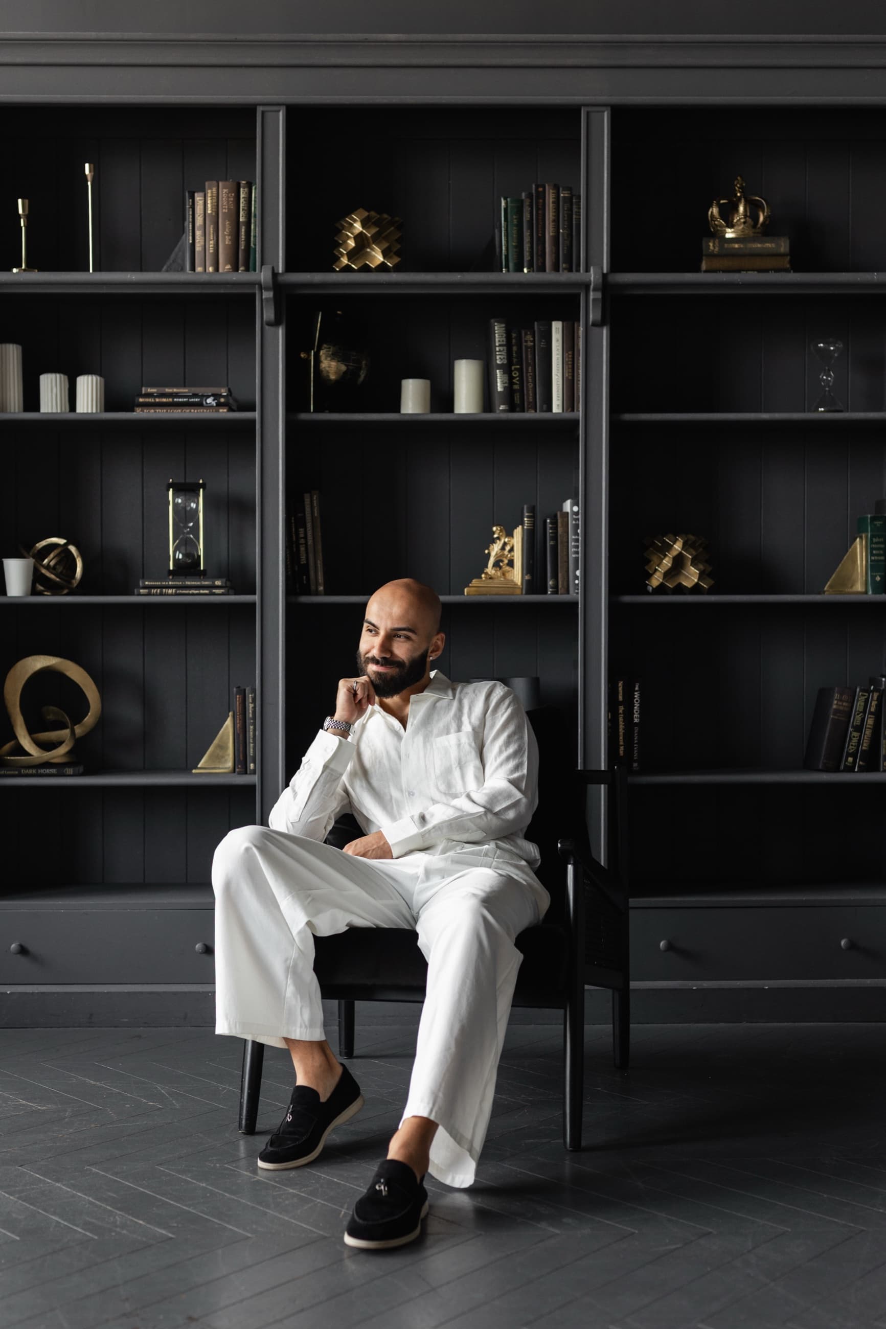 Navid Rashid seated in front of a library wall
