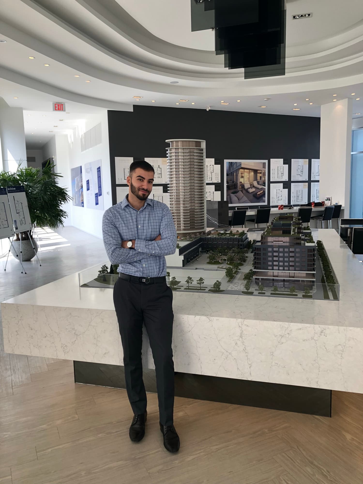 Navid Rashid standing beside a condo model in a sales gallery
